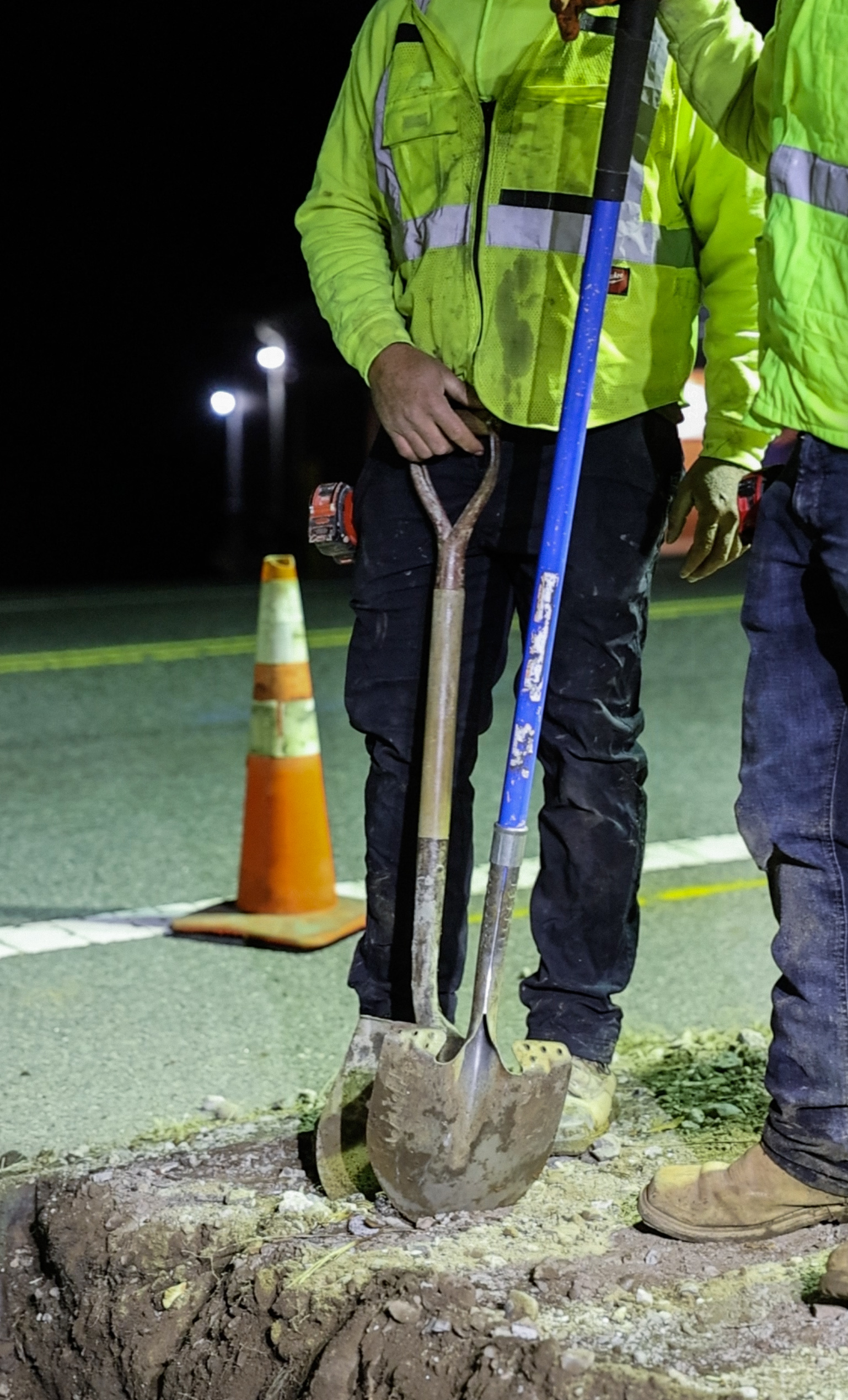 Worker with shovels on road cut