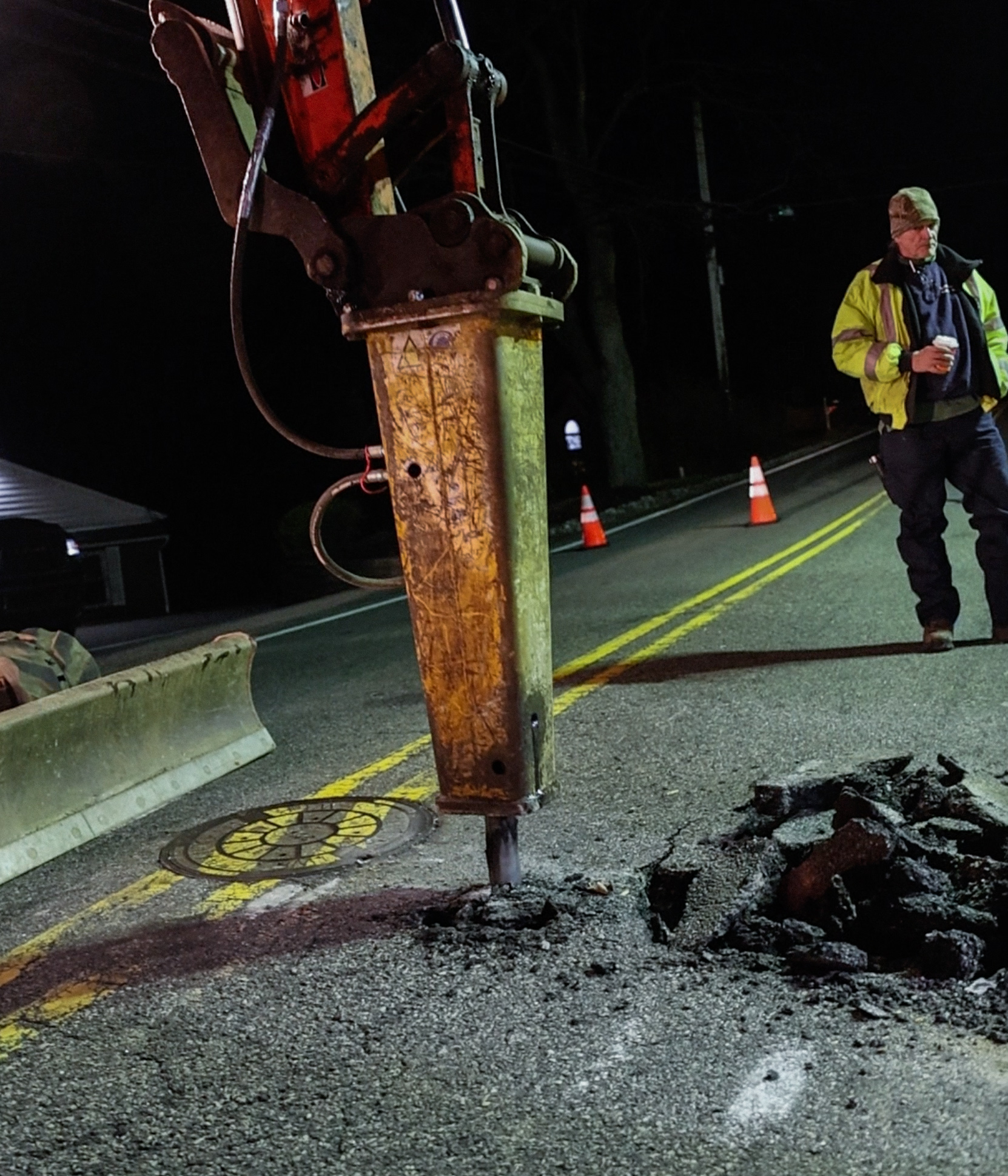 Hydraulic breaker on road excavation at night