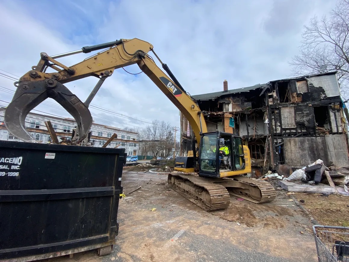 CAT excavator demolishing commercial building